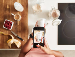 Woman Wearing Fitness Clothing Scanning Qr Code On Food Packaging To Find Nutritional Information